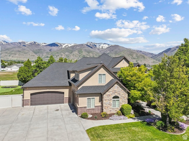1737 S Kerrybrook Dr, Kaysville, UT 84037 - french country inspired facade featuring stucco siding, concrete driveway, stone siding, an attached garage, and a mountain view