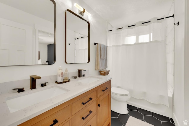 bathroom featuring toilet, double vanity, and shower / bath combo with shower curtain