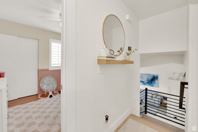 hall featuring an upstairs landing and wood finished floors