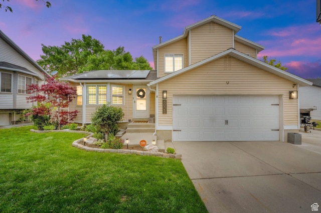 view of front facade featuring solar panels, driveway, an attached garage, and a front lawn