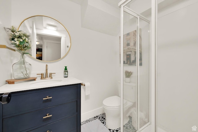 full bath featuring a stall shower, vanity, toilet, tile patterned flooring, and baseboards