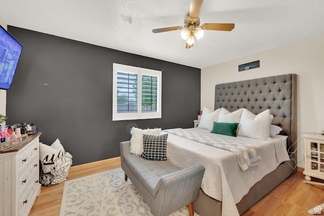 bedroom with light wood-style floors and a ceiling fan