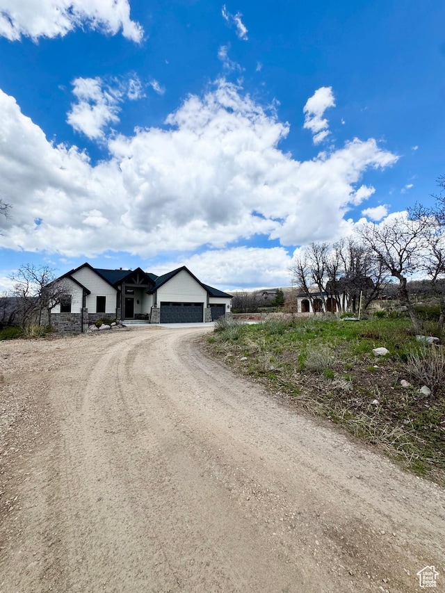 9351 E Acorn Cir Unit 921, Heber City, UT 84032 - view of front of house with an attached garage, dirt driveway, and stone siding
