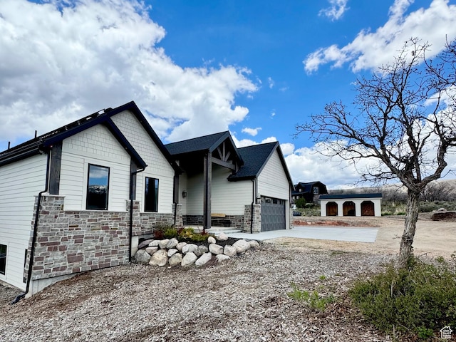 9351 E Acorn Cir Unit 921, Heber City, UT 84032 - view of property exterior featuring concrete driveway, an attached garage, and stone siding