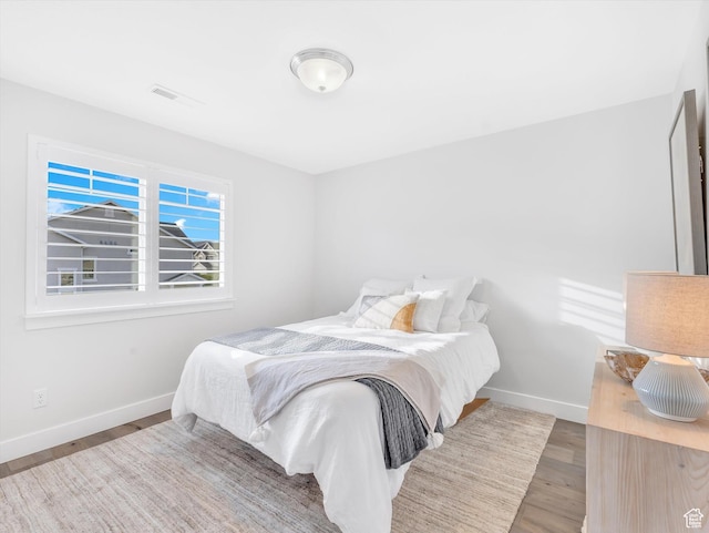 bedroom with baseboards and wood finished floors