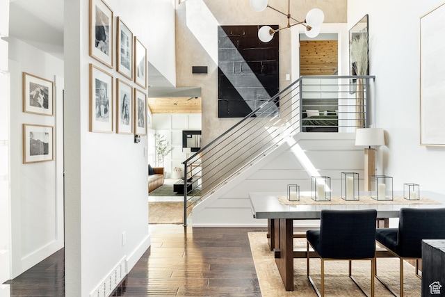 entrance foyer with wood finished floors, stairs, a chandelier, and baseboards