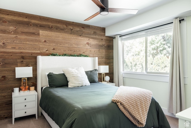 bedroom with carpet, wood walls, and ceiling fan