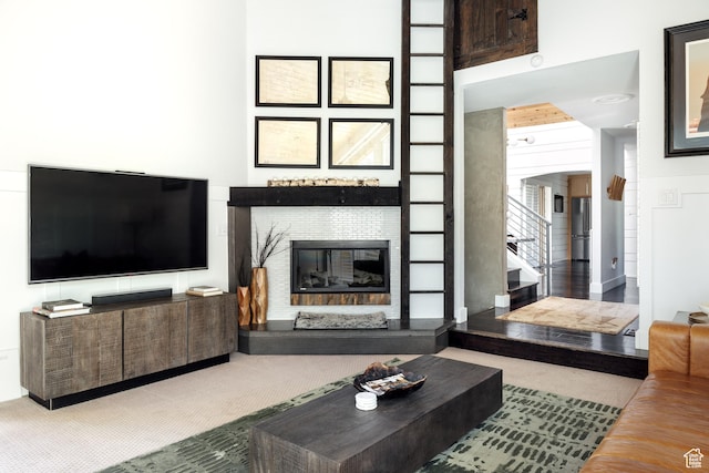 living room featuring carpet and a glass covered fireplace