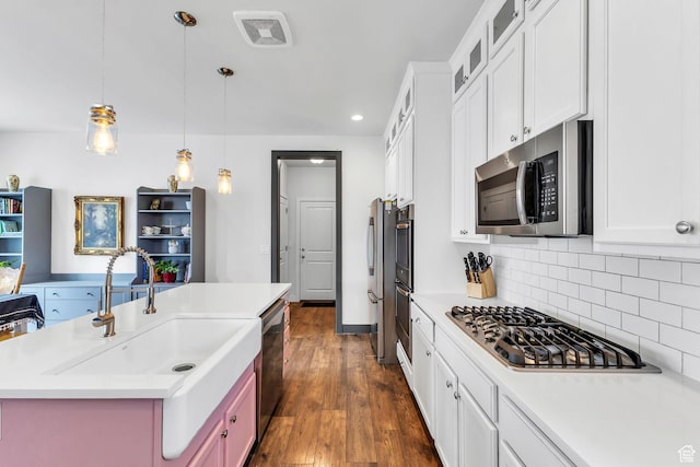 11386 S New Bern Way S, Jordan, UT 84009 - kitchen with stainless steel appliances, tasteful backsplash, light countertops, a sink, and hanging light fixtures