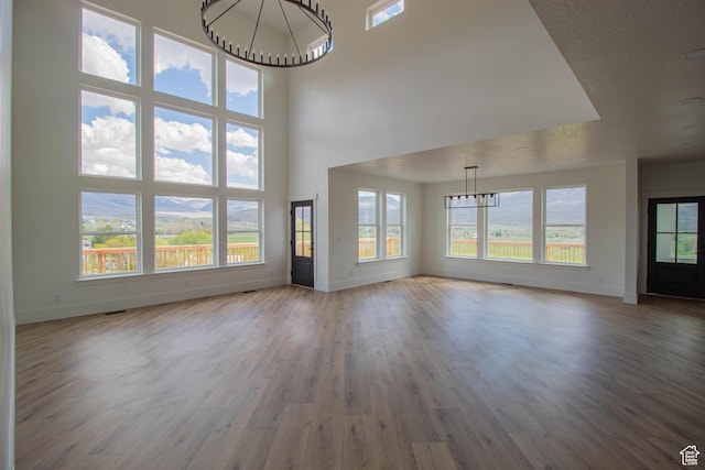 479 S 550 E, Wallsburg, UT 84082 - unfurnished living room featuring a chandelier, baseboards, wood finished floors, and a high ceiling