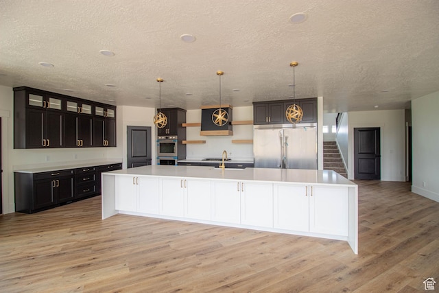 479 S 550 E, Wallsburg, UT 84082 - kitchen with stainless steel appliances, a textured ceiling, open shelves, light wood-type flooring, and a spacious island