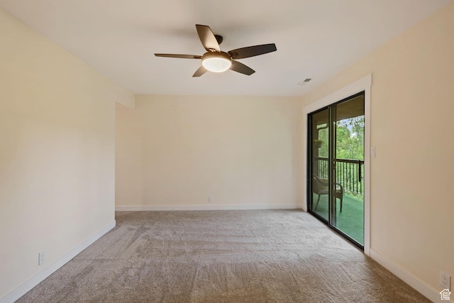 carpeted spare room with ceiling fan and baseboards