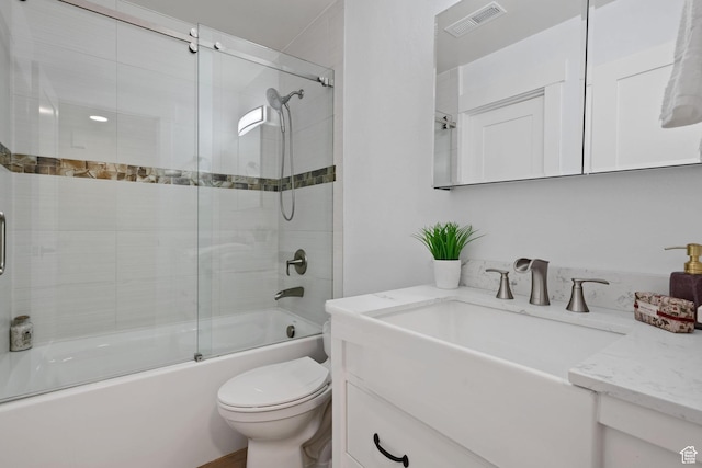 full bathroom with vanity, toilet, and shower / bath combination with glass door