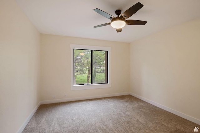 carpeted spare room with baseboards and ceiling fan