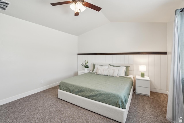 carpeted bedroom featuring vaulted ceiling, a ceiling fan, and a wainscoted wall