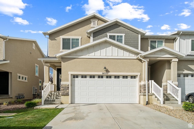 view of front of house featuring stone siding, stucco siding, concrete driveway, and board and batten siding