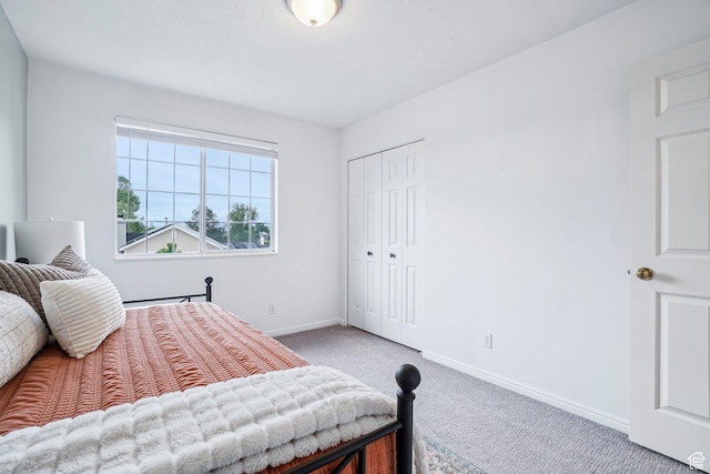 bedroom with carpet floors, baseboards, and a closet