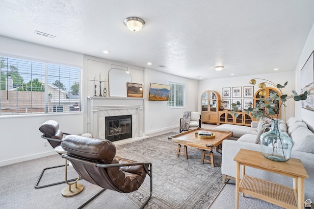 living area featuring healthy amount of natural light, a fireplace, baseboards, and recessed lighting