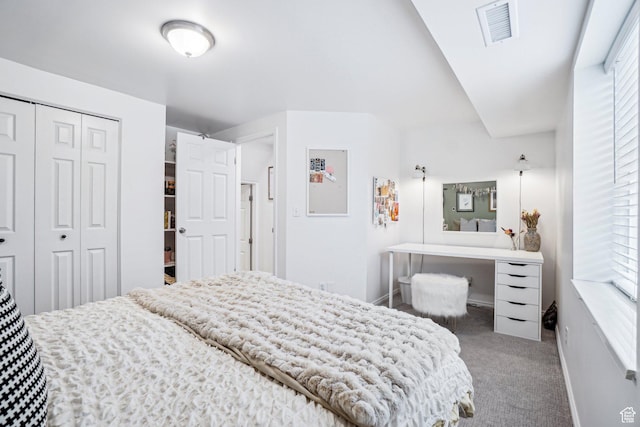 carpeted bedroom featuring a closet and baseboards