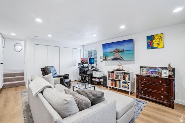 living area with light wood-type flooring, stairway, recessed lighting, and baseboards