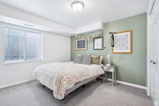 carpeted bedroom featuring baseboards and a closet