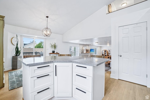 kitchen with light wood-style flooring, a chandelier, healthy amount of natural light, and lofted ceiling