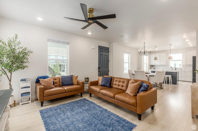 6781 W Meadow Grass Dr, South Jordan, UT 84009 - living room with healthy amount of natural light, a chandelier, ceiling fan, light wood finished floors, and recessed lighting