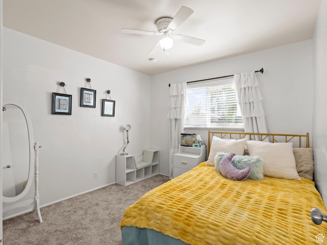 carpeted bedroom with ceiling fan and baseboards