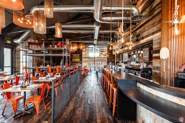 indoor dry bar featuring wood-type flooring and wooden walls