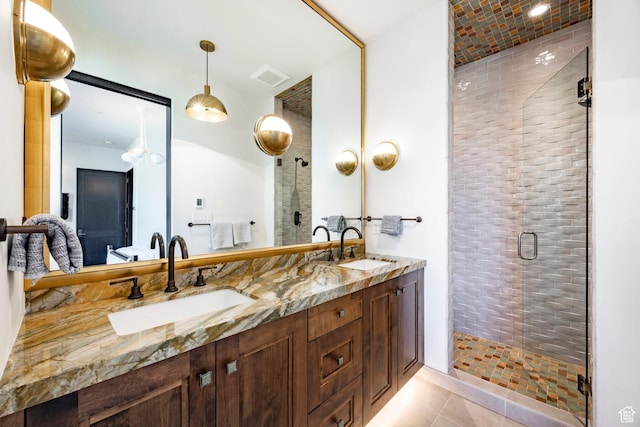 bathroom featuring a shower stall, double vanity, and tile patterned flooring