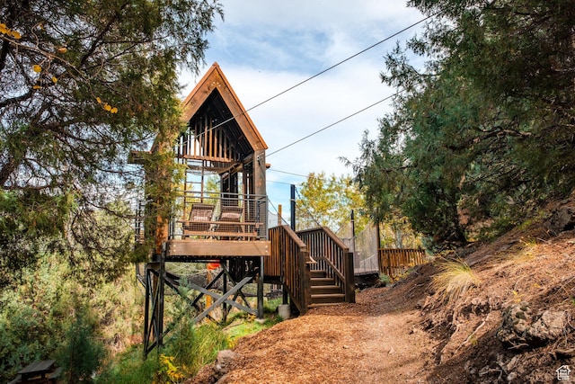 view of side of property featuring stairway and a deck
