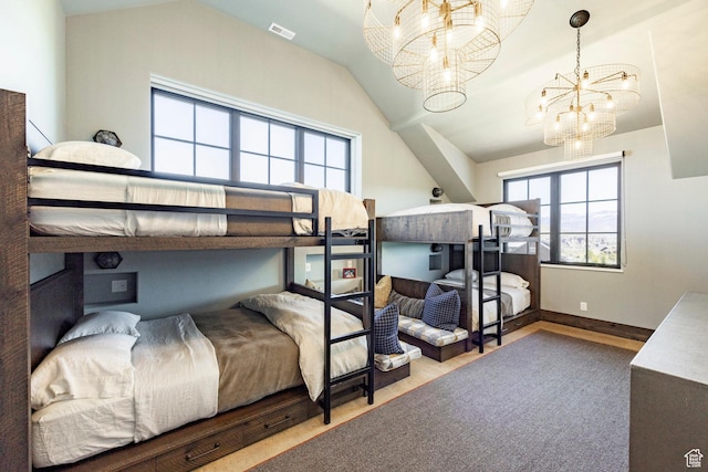 bedroom with a chandelier, vaulted ceiling, and wood finished floors
