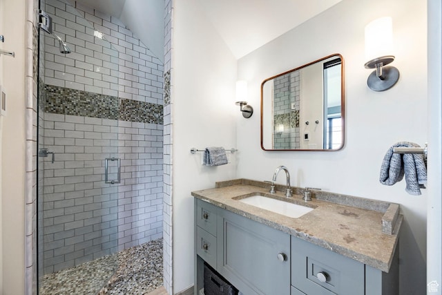 full bathroom with a shower stall, vanity, and lofted ceiling