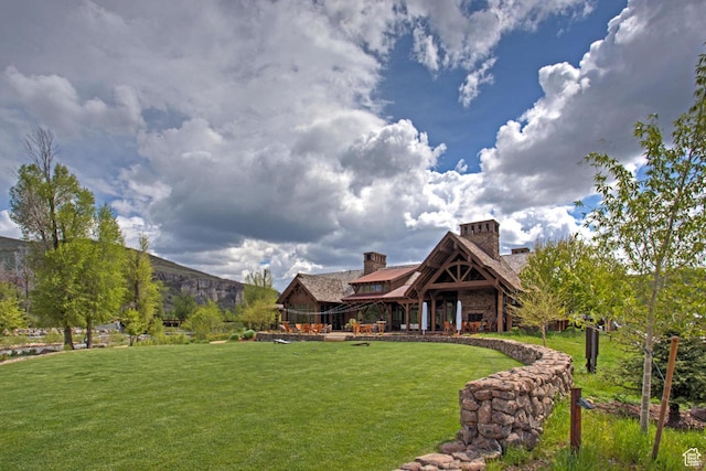 rear view of property with a lawn and a chimney
