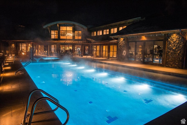 pool at twilight featuring an outdoor pool and a patio area