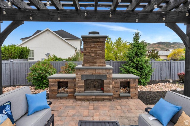 3106 N Eagle Way, Lehi, UT 84043 - view of patio with an outdoor stone fireplace, a fenced backyard, a mountain view, and a pergola
