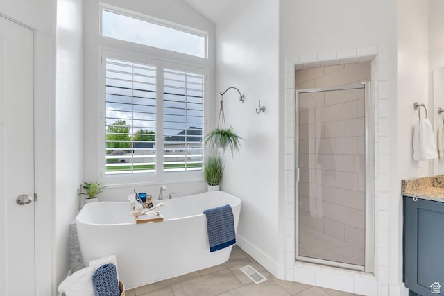 bathroom with a shower stall, tile patterned flooring, a soaking tub, vanity, and baseboards