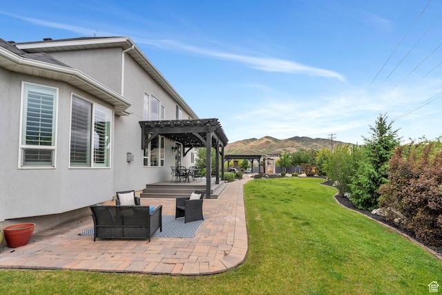 view of grassy yard with a pergola, a patio, an outdoor hangout area, and a mountain view