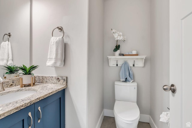 bathroom with baseboards, vanity, toilet, and tile patterned floors