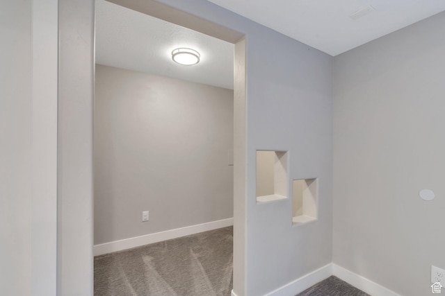empty room featuring baseboards and carpet floors