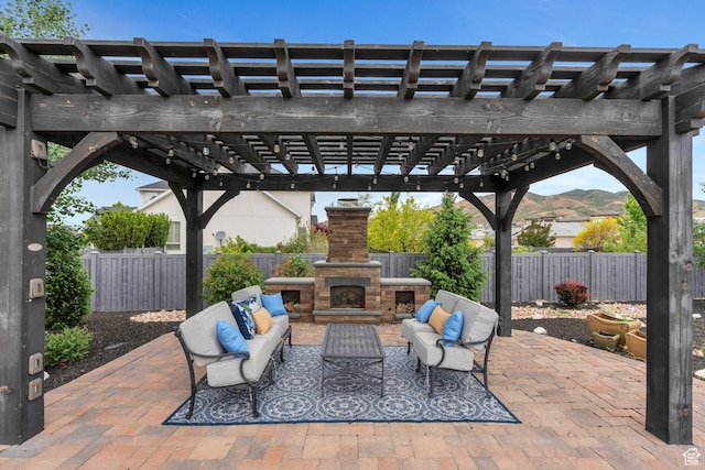 view of patio / terrace with an outdoor living space with a fireplace, a fenced backyard, and a pergola