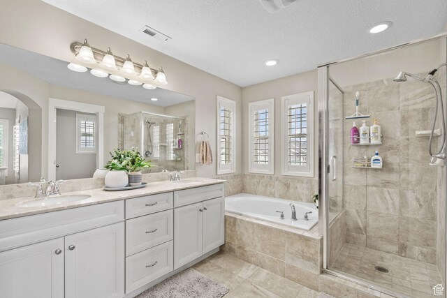 10426 S Kestrel Rise Rd, South Jordan, UT 84009 - bathroom featuring a shower stall, a garden tub, double vanity, tile patterned floors, and a textured ceiling
