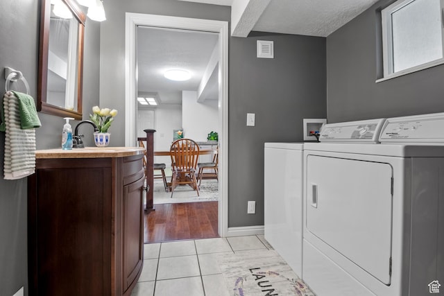 7479 S Randall Cir, Midvale, UT 84047 - laundry room with washing machine and clothes dryer, a textured ceiling, baseboards, and light tile patterned flooring