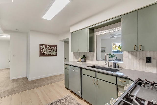 kitchen featuring a sink, stainless steel dishwasher, tasteful backsplash, light wood-style floors, and a ceiling fan