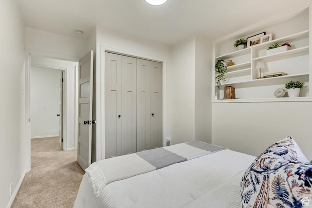 carpeted bedroom featuring a closet and baseboards