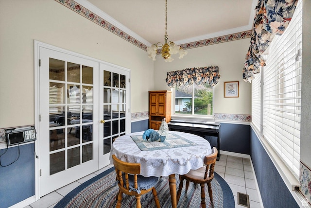 dining area with a chandelier, light tile patterned floors, french doors, baseboards, and crown molding