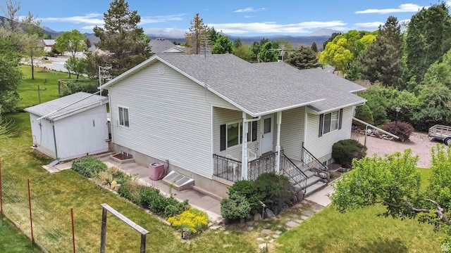 view of front of property featuring a shingled roof, a front yard, entry steps, and a mountain view
