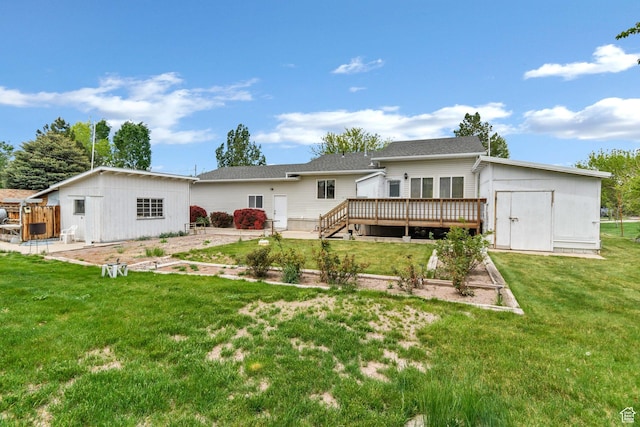 back of property featuring a wooden deck, an outbuilding, a storage shed, a lawn, and a garden