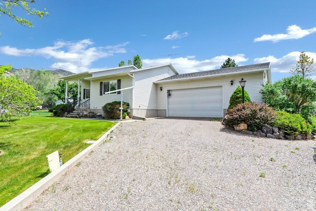 ranch-style house with gravel driveway, an attached garage, and a front yard