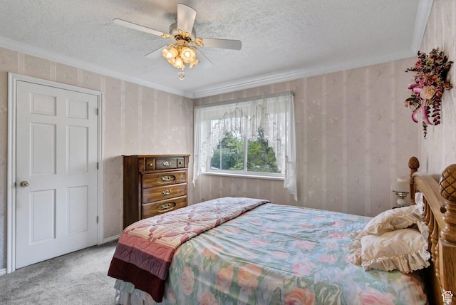 bedroom featuring carpet floors, a textured ceiling, ornamental molding, and ceiling fan